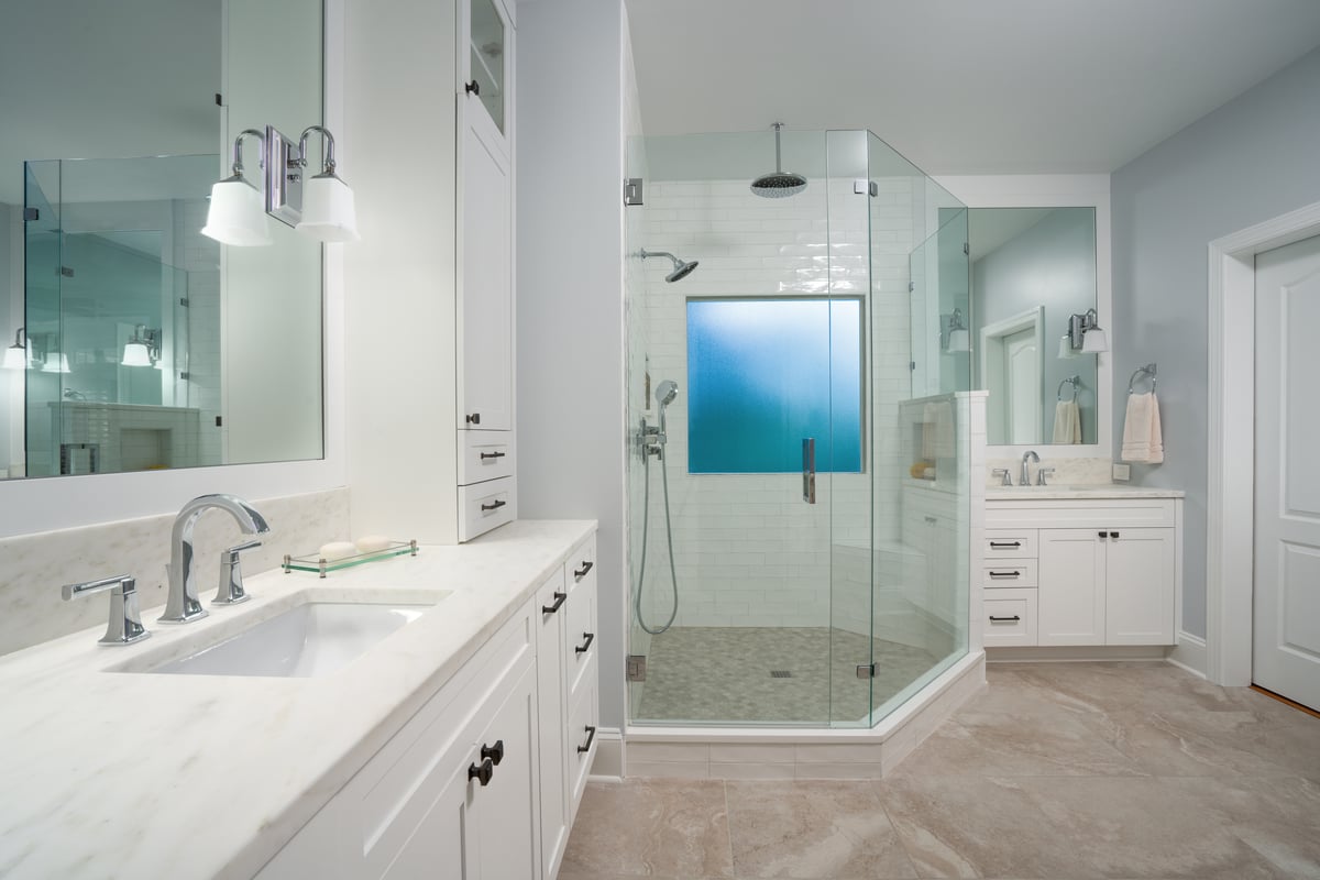 Primary bathroom remodel in Charlotte, NC with large shower, dual vanities and framed mirrors by Distinctive Design + Build + Remodel.