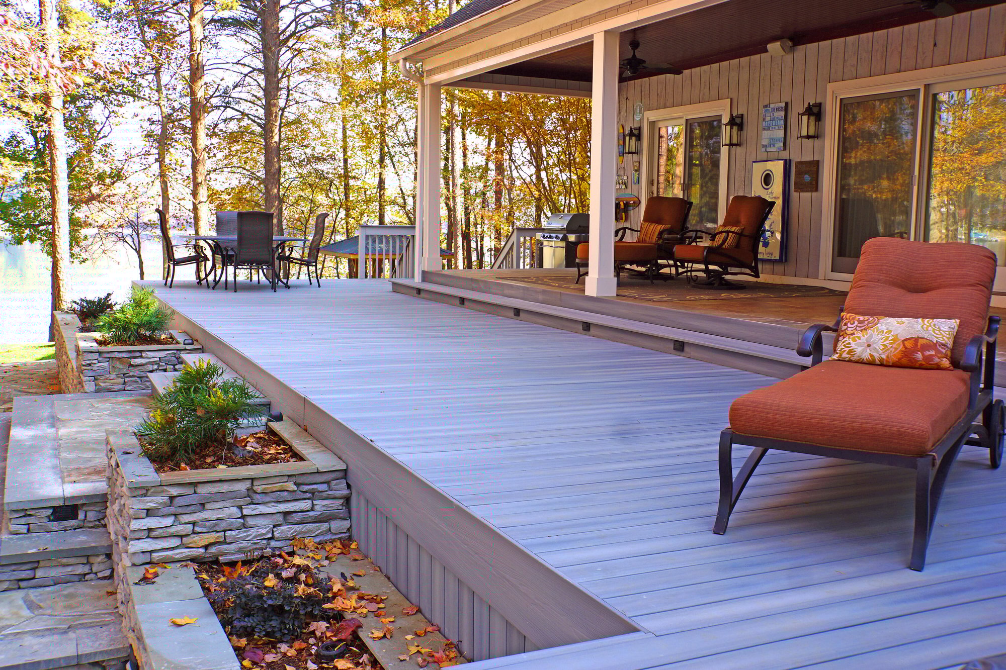 Fiberon deck with natural stone planters and dining area by Distinctive Design + Build + Remodel on Lake Norman.