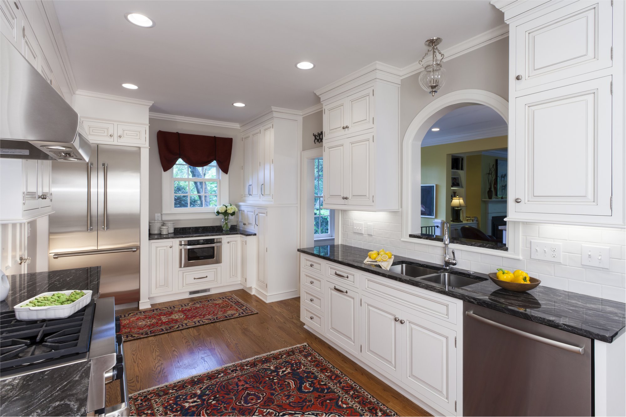 Award-winning kitchen in Charlotte, NC with white cabinetry and arched passthrough by Distinctive Design Build Remodel
