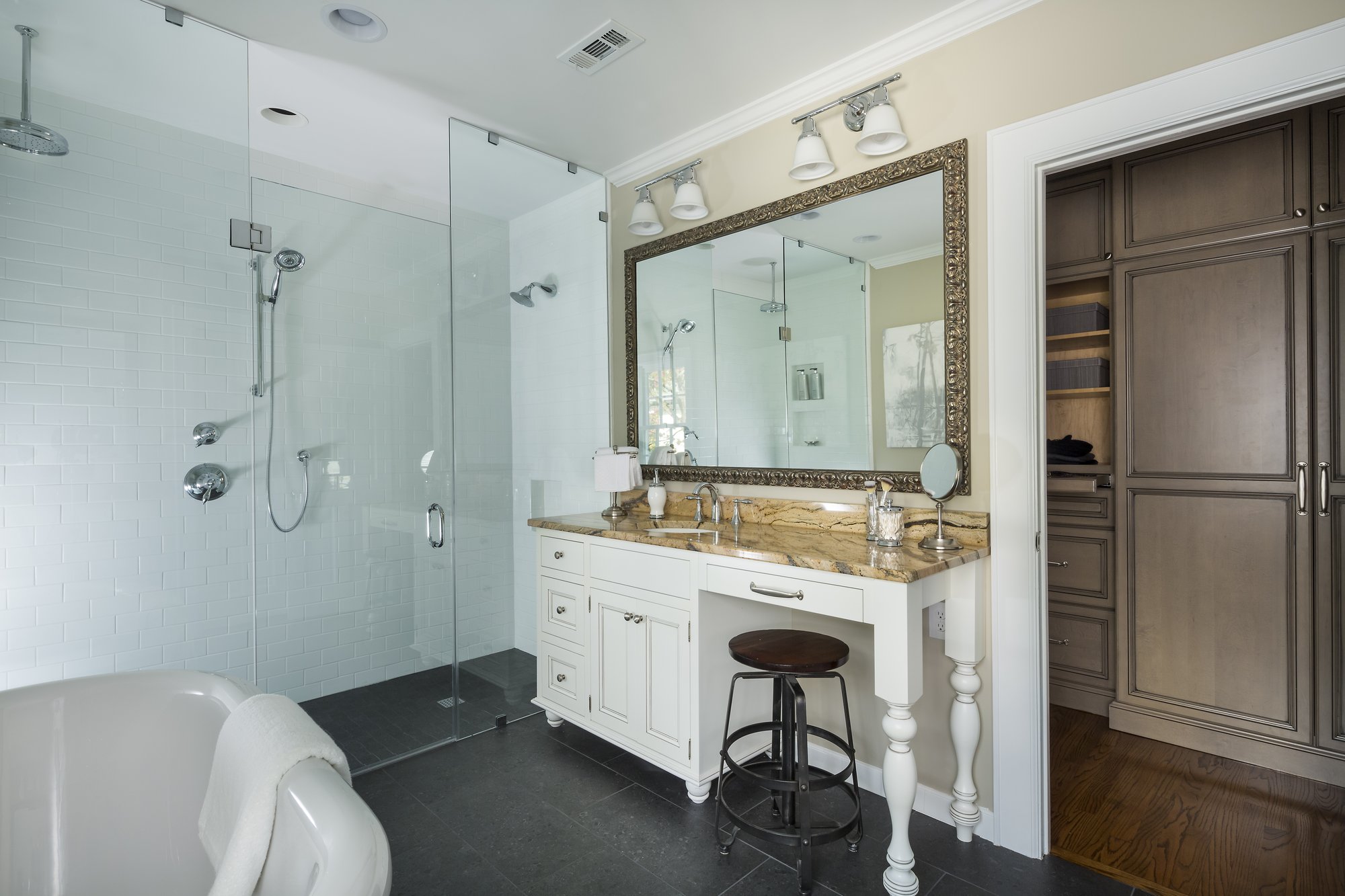 Primary bathroom remodel with expansive barrier-free shower, custom cabinetry and a free-standing tub in Myers Park by Distinctive Design + Build + Remodel.