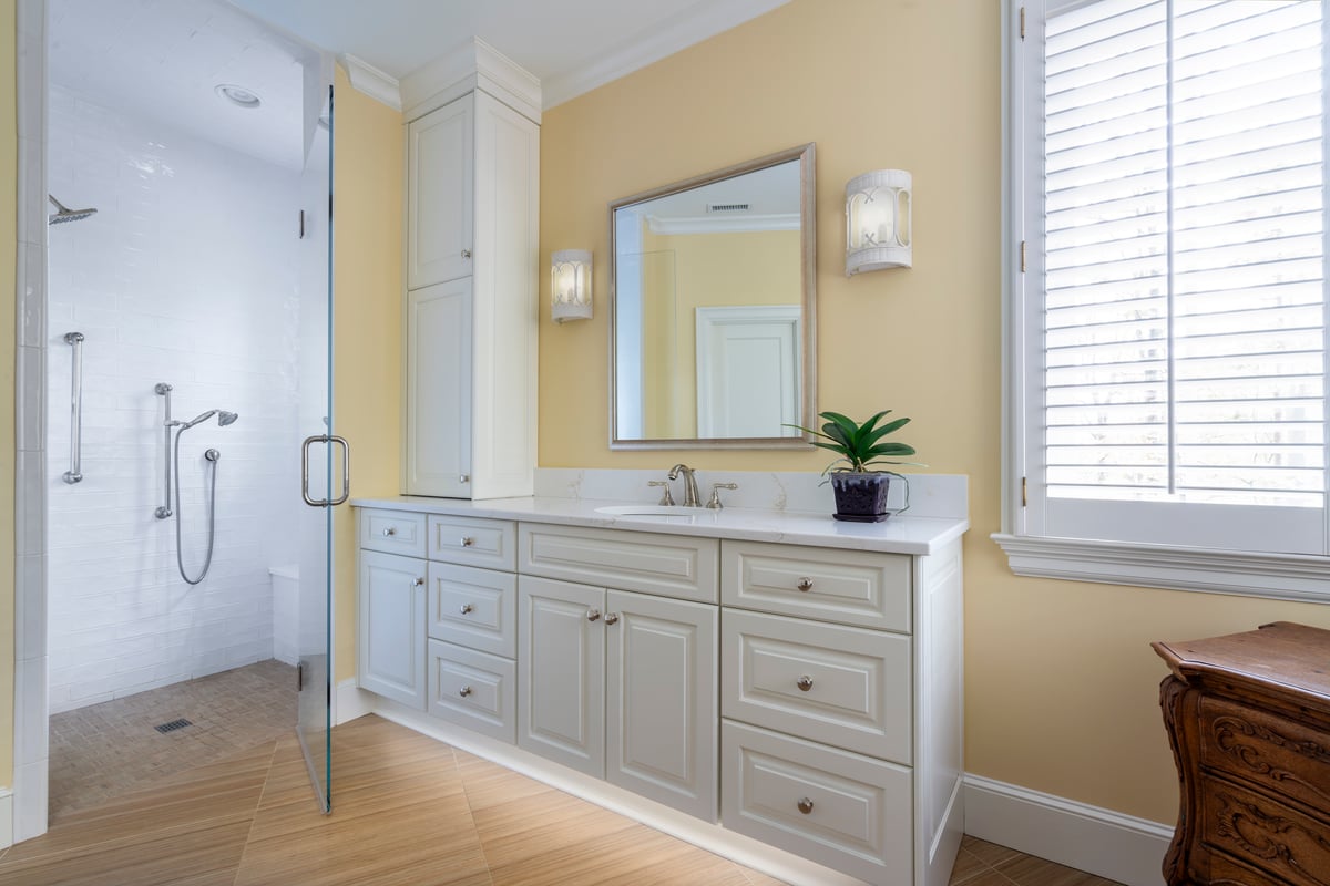 Primary bathroom remodel by Distinctive Design + Build + Remodel in Waxhaw, NC with curbless shower and LED lights on the vanity toe kick.