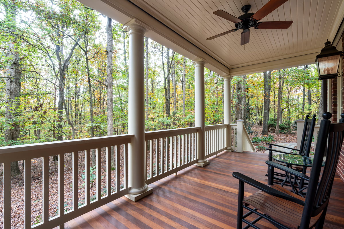 Porch renovation with new Ipe hardwood floor boards and composite railing in Waxhaw, NC by Distinctive Design + Build + Remodel.