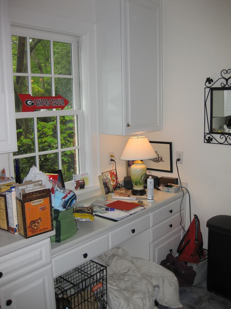 A built-in desk piled with papers in a kitchen in Myers Park before a major remodel by Distinctive Design + Build + Remodel | Charlotte, NC.