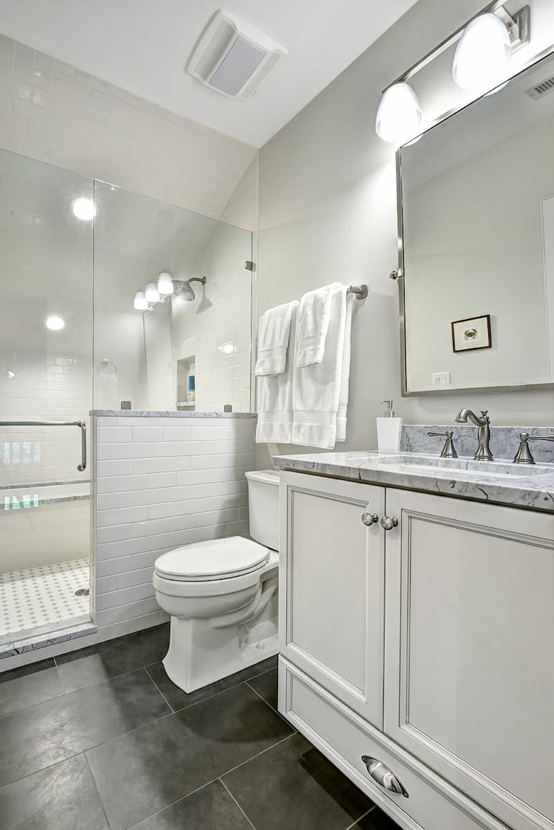 Attic space converted to bathroom with white and gray tile on Kiawah Island, SC by Distinctive Design + Build + Remodel.