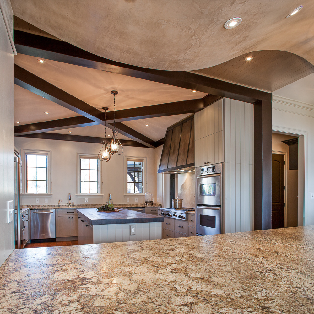 Hand-stained cross-beam on the ceiling of a Lake Norman kitchen remodel by Distinctive Design + Build + Remodel.
