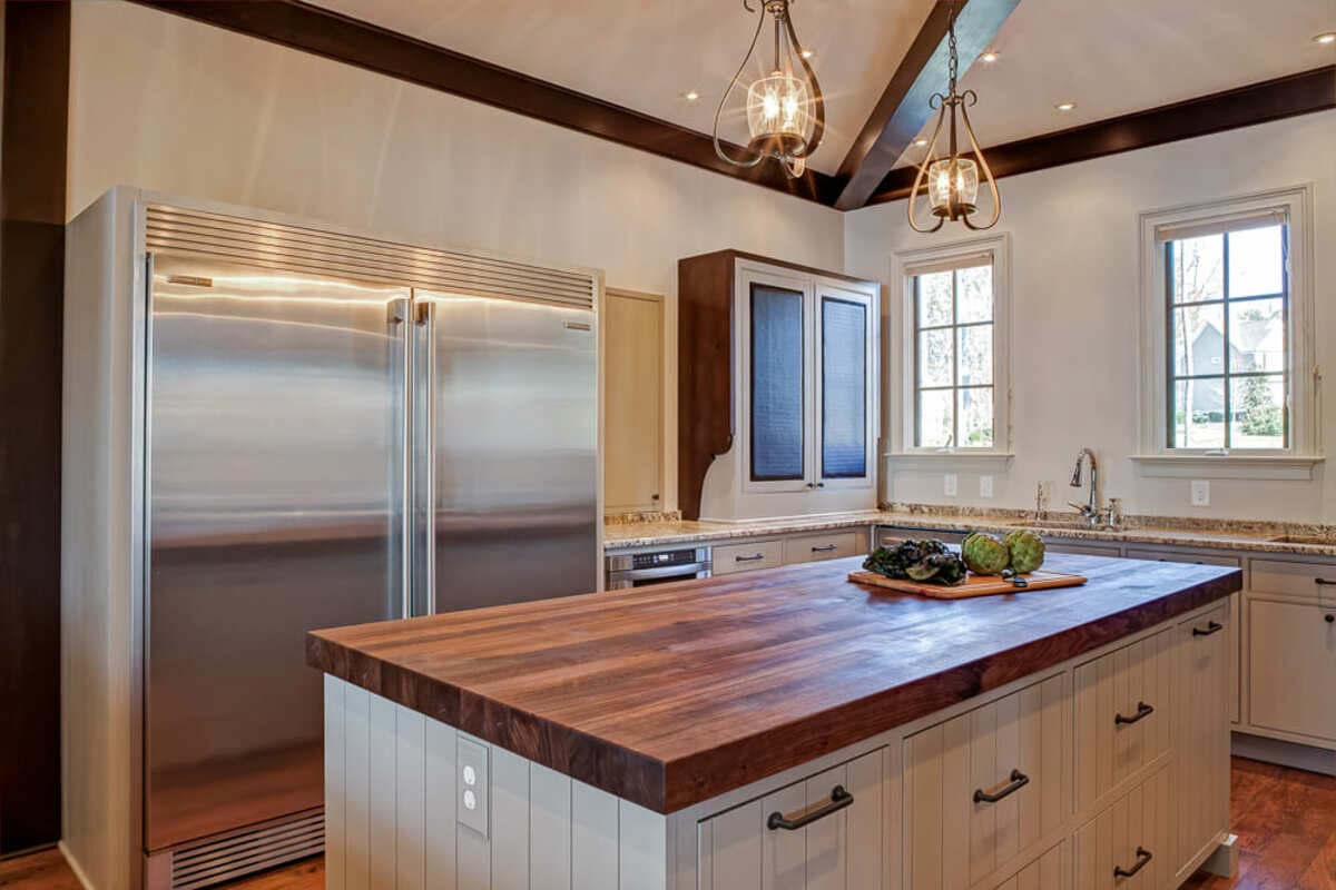 Walnut countertop on kitchen island in Davidson, NC by Distinctive Design + Build + Remodel.
