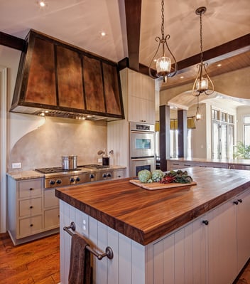Venetian plaster backsplash, custom metal hood and black walnut countertop in a kitchen remodel on Lake Norman by Distinctive Design + Build + Remodel.