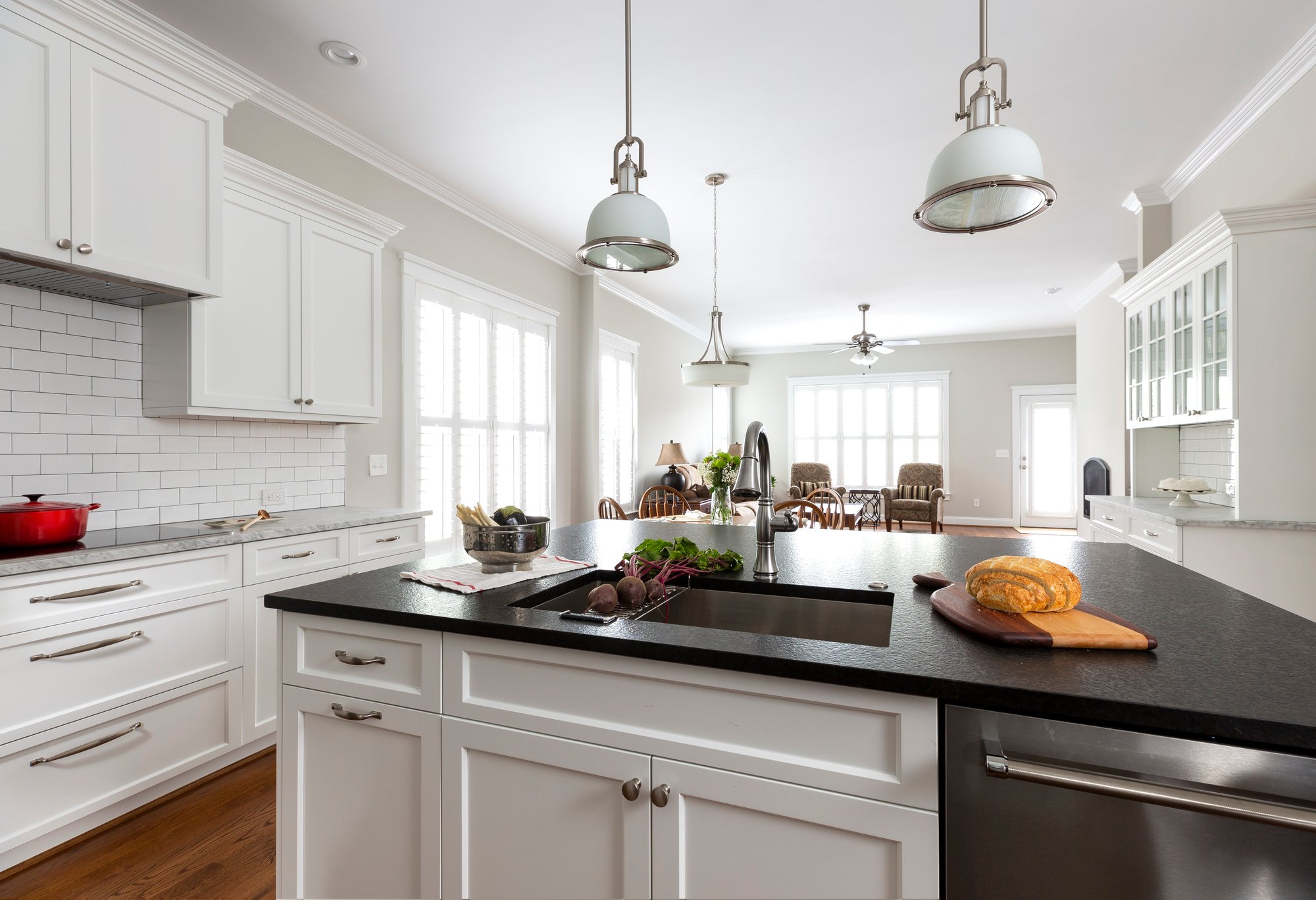 Kitchen remodel in Belmont, NC with white cabinetry and leathered granite countertops by Distinctive Design + Build + Remodel.