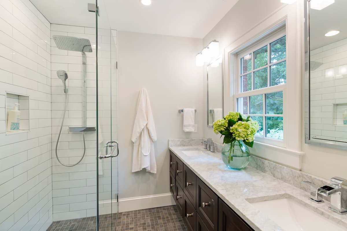 National award-winning primary bathroom remodel in Myers Park by Distinctive Design + Build + Remodel with a barrier-free shower, wall-hung vanity and Hansgrohe shower tower.