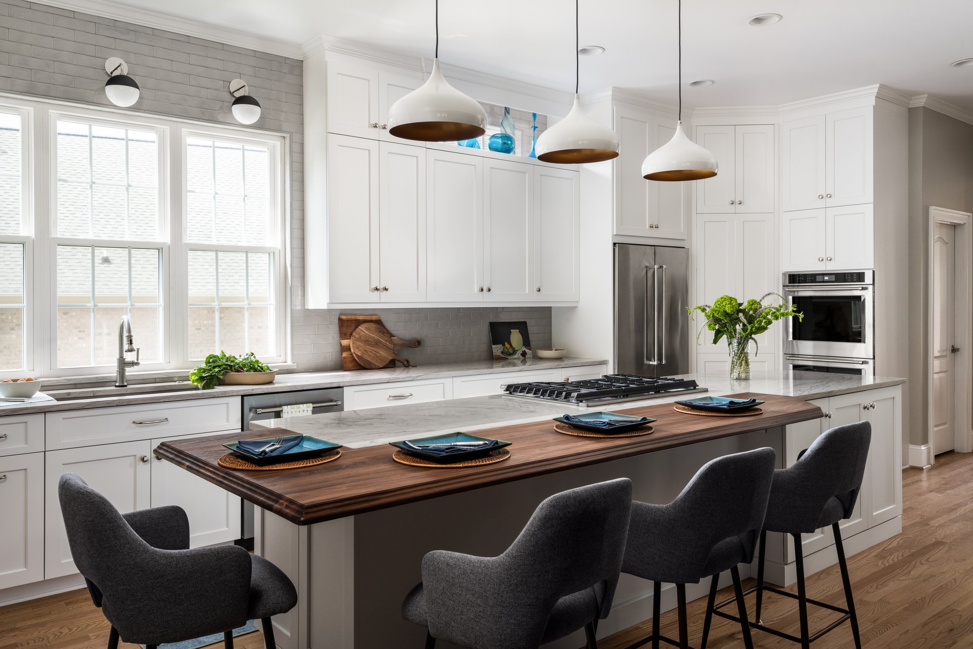 Walnut seating bar in a white kitchen with creamy quartzite countertops in Charlotte, NC by Distinctive Design Build Remodel