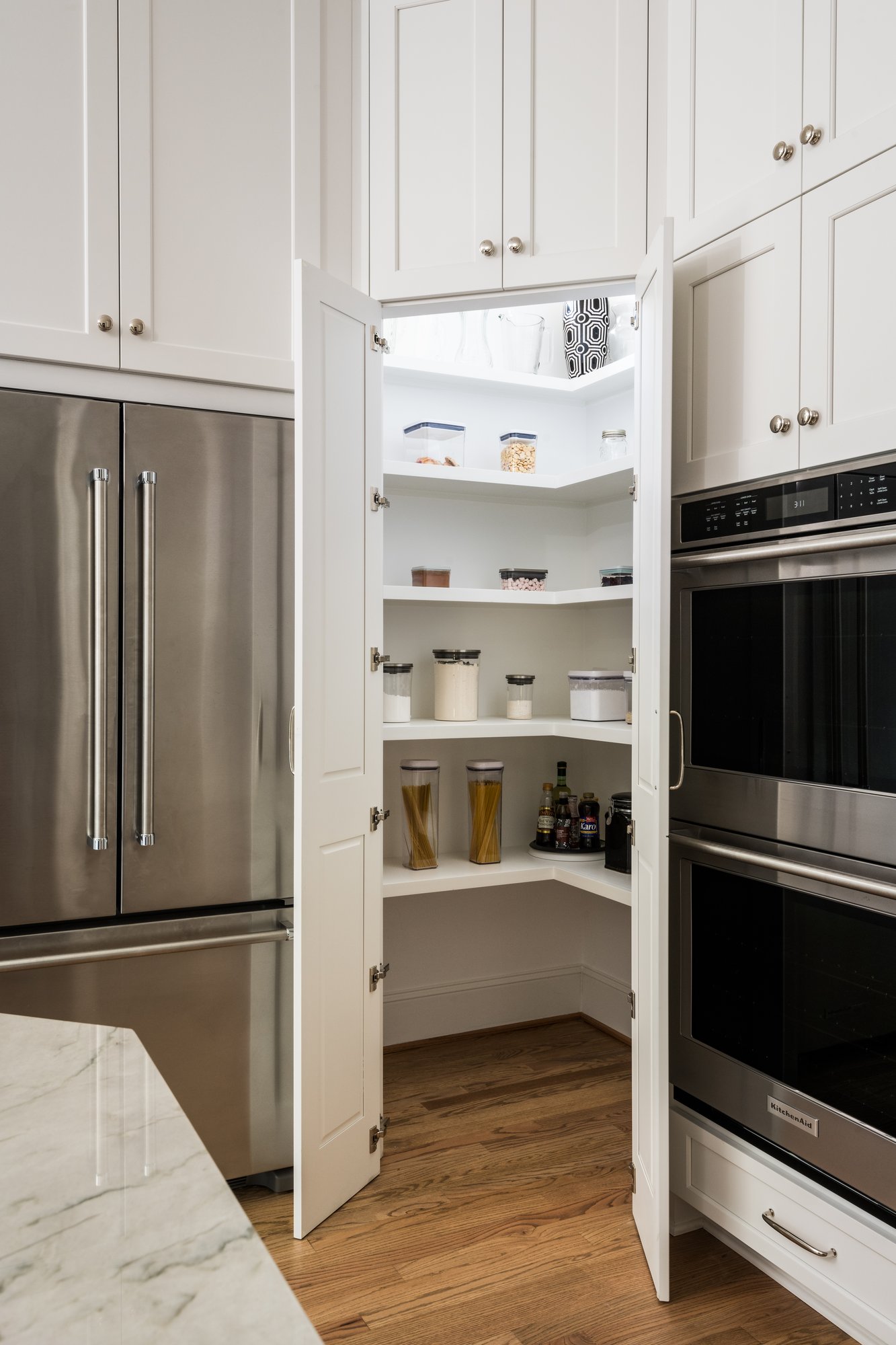 Secret pantry disguised to look like cabinetry in a kitchen remodel by Distinctive Design + Build + Remodel in Charlotte, NC.