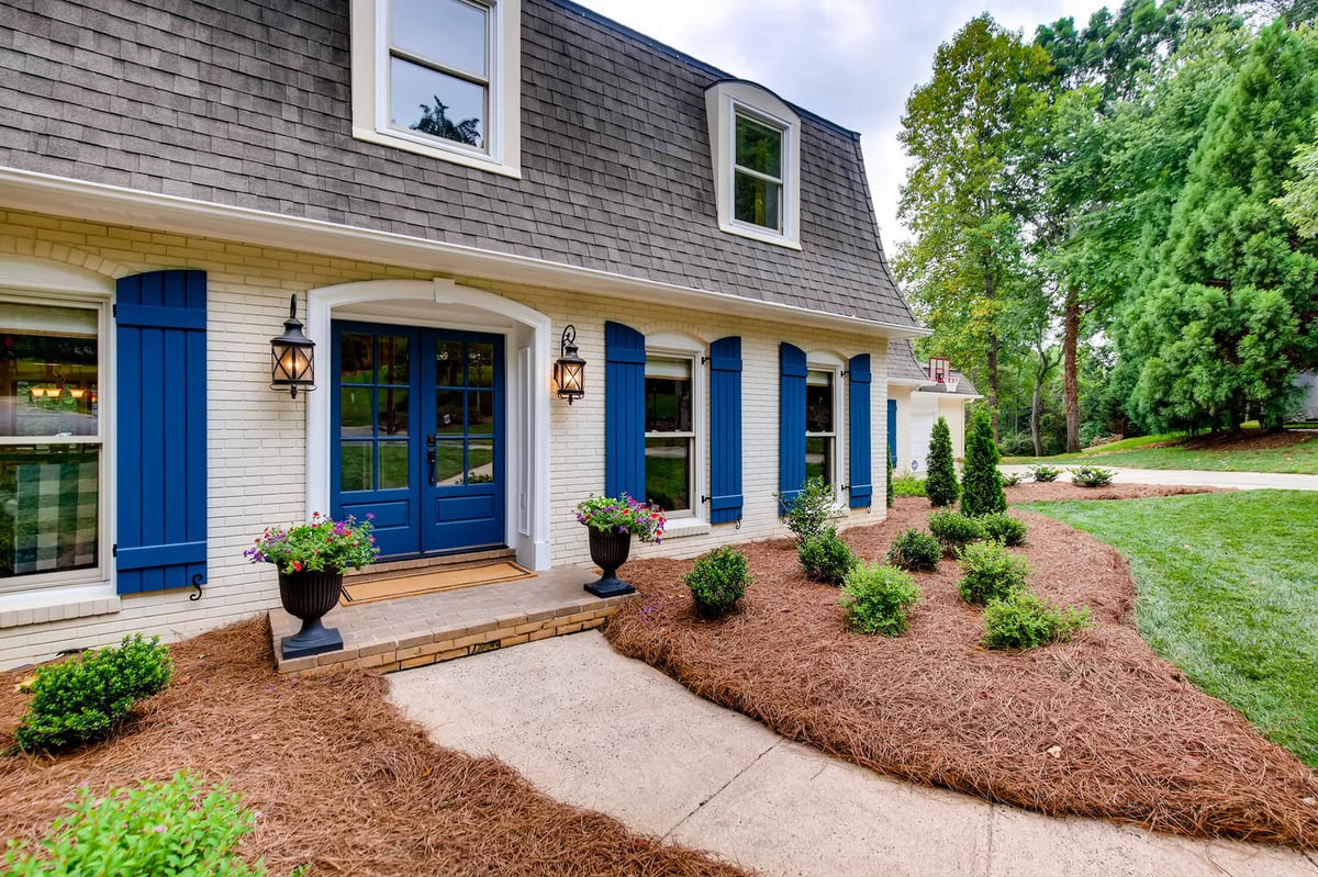 Whole house remodel front entry with blue door and shutters in Charlotte, NC by Distinctive Design + Build + Remodel.