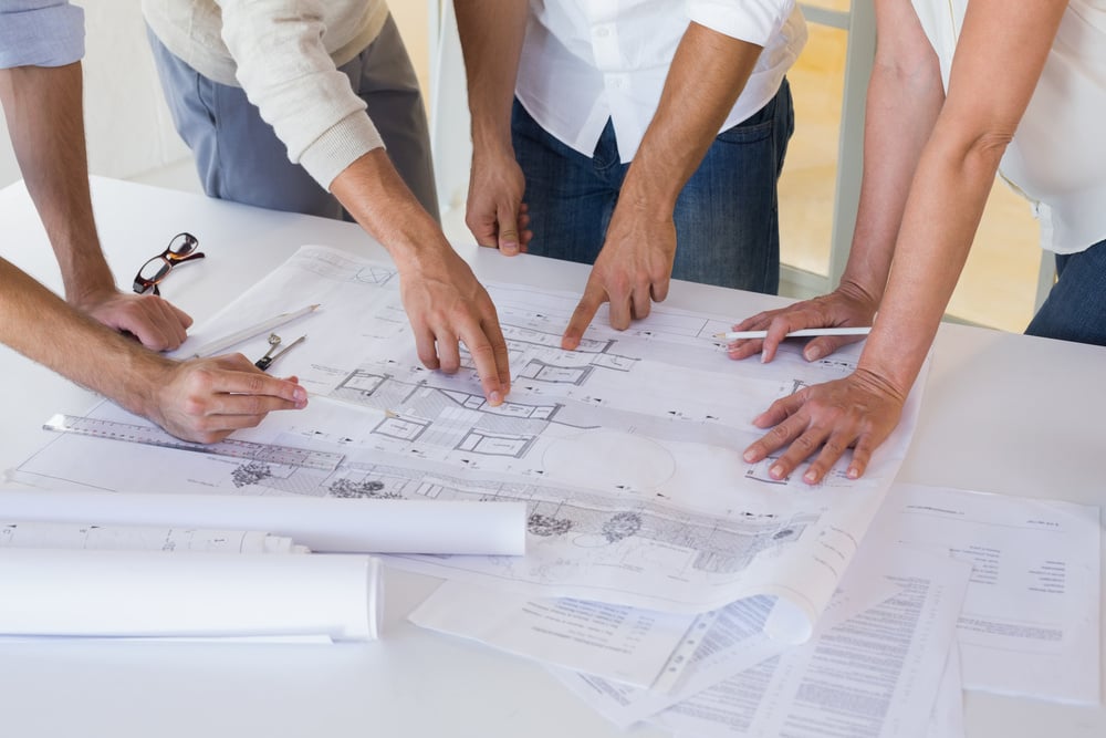 Team of architect, designer and builder working on a construction drawing at Distinctive Design + Build + Remodel in Charlotte, NC.