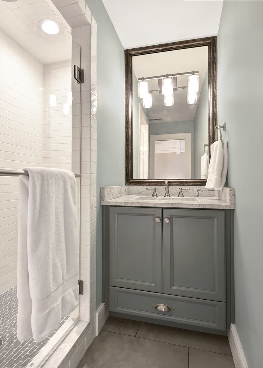 Hall bathroom remodel with blue vanity and carrara marble countertops by Distinctive Design + Build + Remodel in Charlotte, NC
