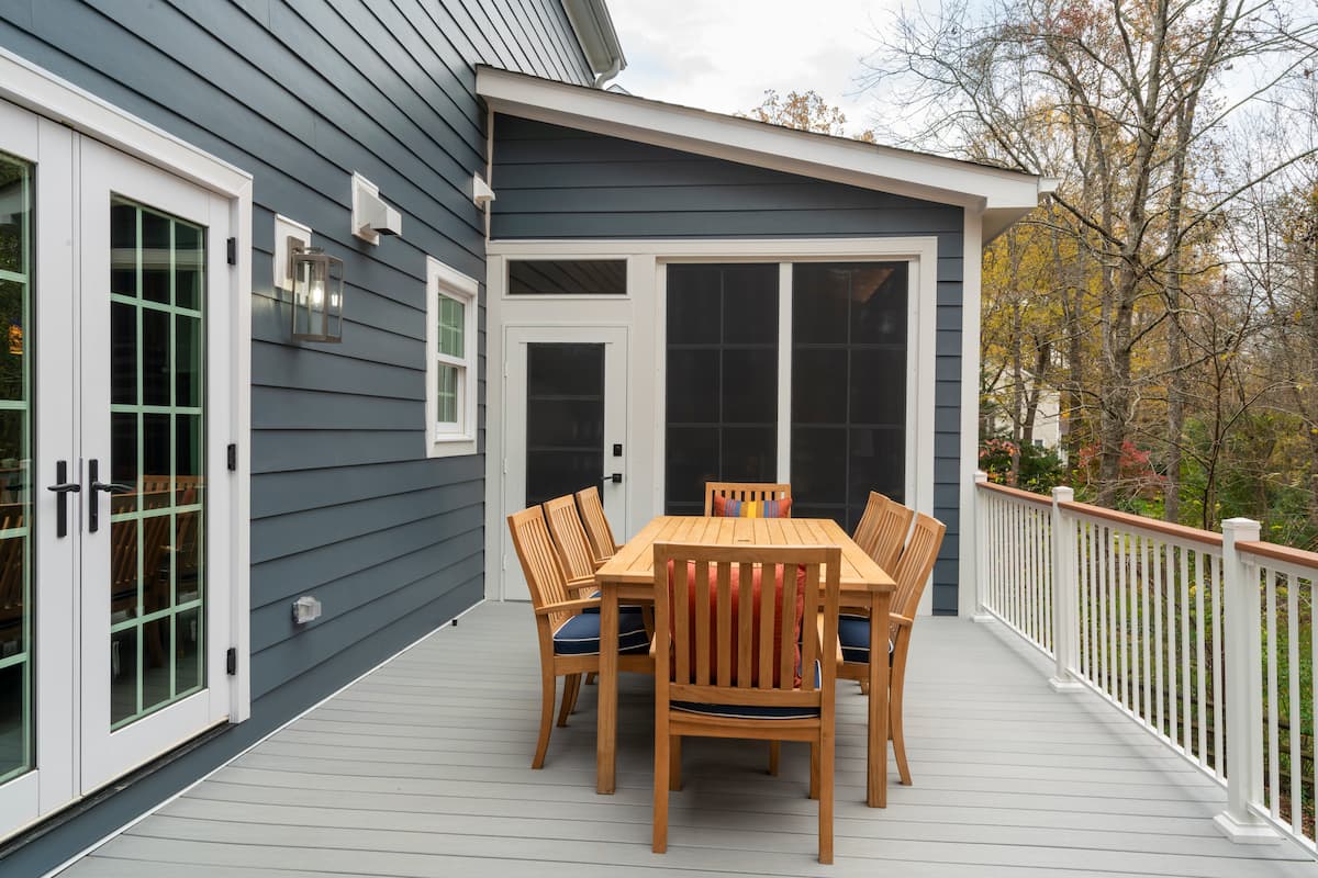 Deck renovation and sunroom addition with Eze Breeze windows in Charlotte, NC by Distinctive Design + Build + Remodel.