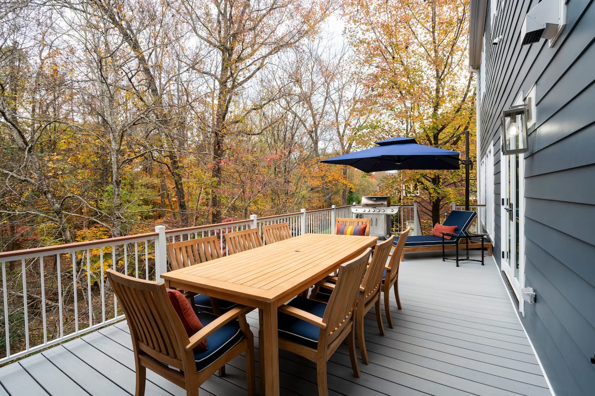 Gray Trex decking and white composite handrails creates a beautiful outdoor living space in Charlotte, NC by Distinctive Design + Build + Remodel.