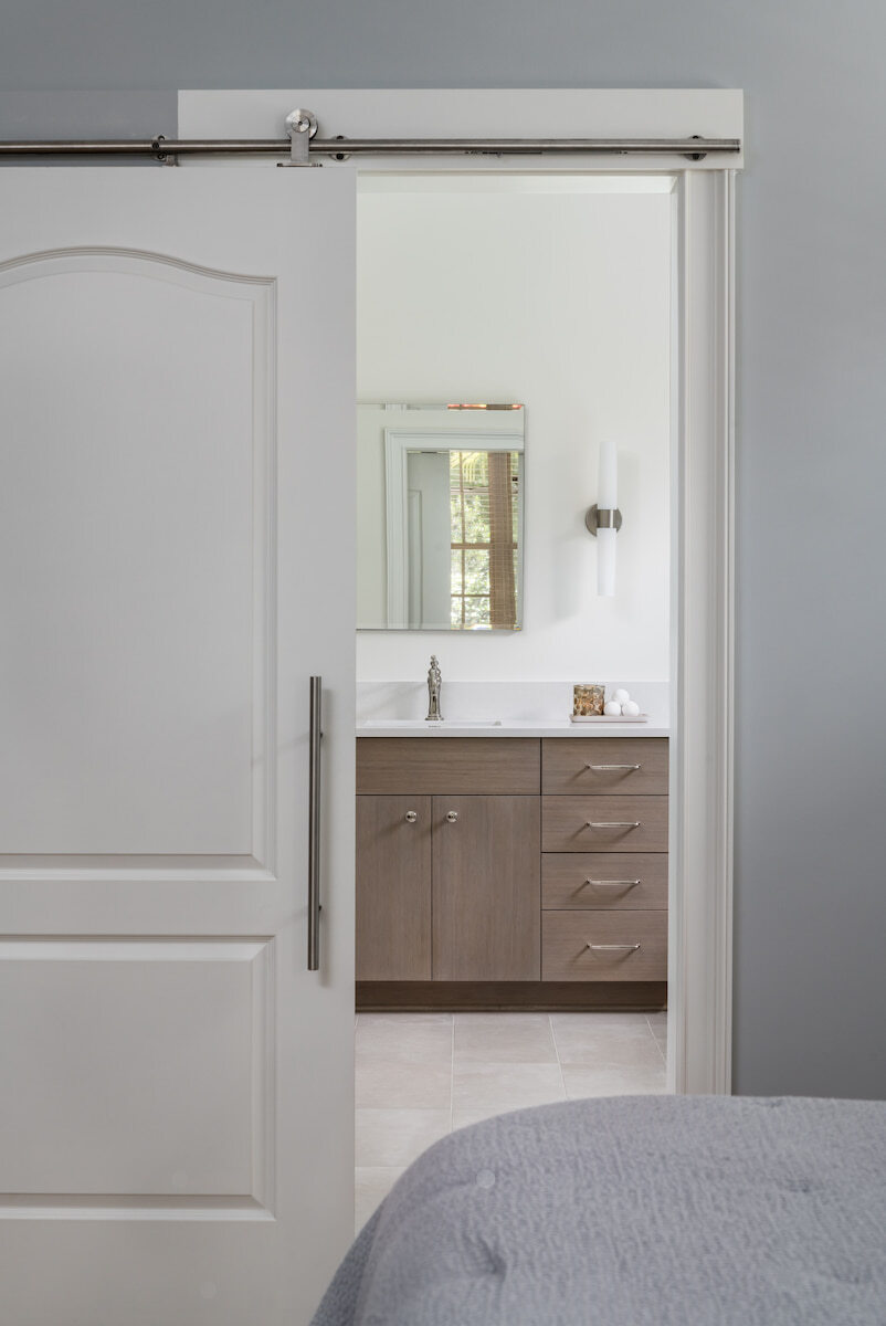 Master bathroom remodel with barn door in Charlotte, NC by Distinctive Design + Build + Remodel.