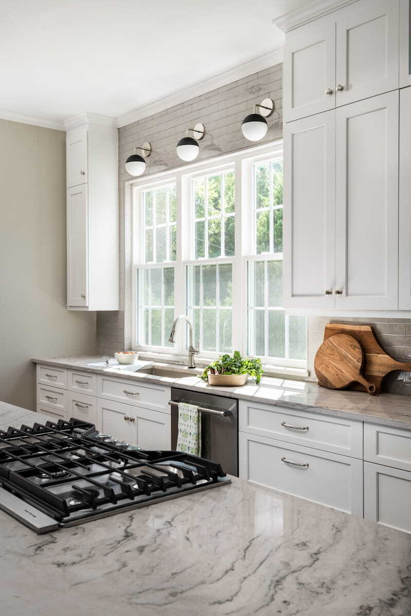 Quartzite countertop with gas cooktop in a kitchen remodel by Distinctive Design + Build + Remodel in Charlotte, NC.