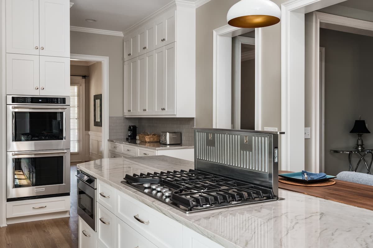 Gas cooktop on a kitchen island with a downdraft in a kitchen remodel in Charlotte, NC by Distinctive Design + Build + Remodel.