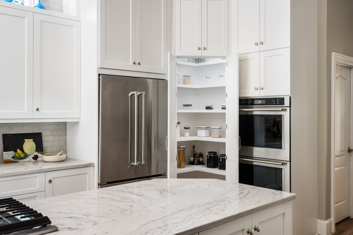 Pantry disguised as cabinetry in a kitchen remodel in Charlotte, NC by Distinctive Design + Build + Remodel.
